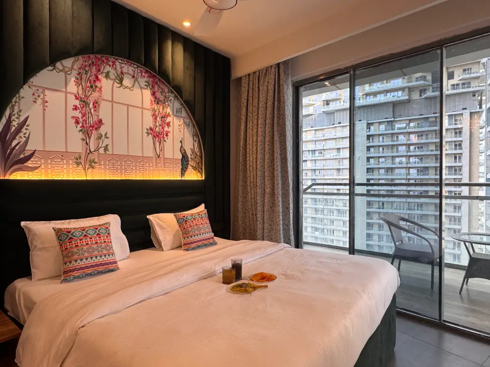 Bedroom with large window view at Supernova Noida Mulberry Homes